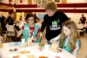 Sylvia Herrera 10 with Ginger Grzyb 10 from Girl Scout troop 70031 are showing Laurie McAbee their Gingerbread house They are making. This is the 25 and last year. Methodist Church Goodrich Dec 3, 16  