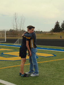 Scott greets son Reilly after running the first leg in the 4 by 800 meter relay on April 12.